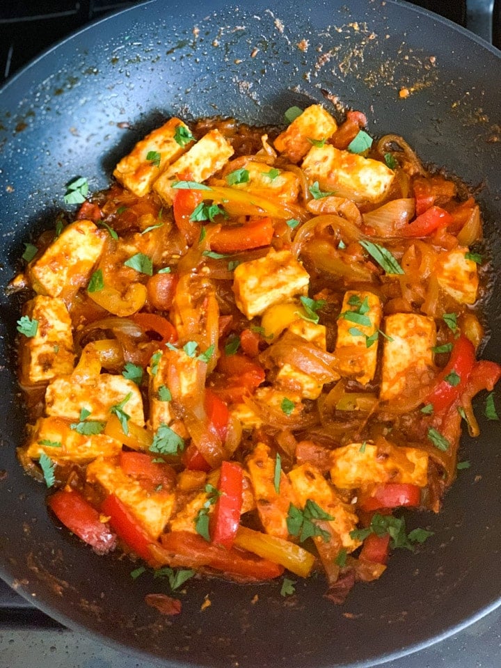 Paneer Jalfrezi step 6 - Piping Pot Curry Paneer with onions and peppers in a pan garnished with cilantro
