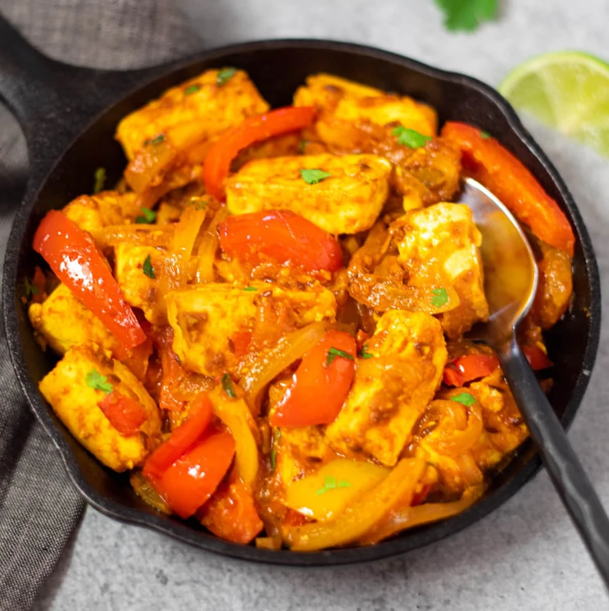 Paneer jalfrezi in a skillet garnished with cilantro