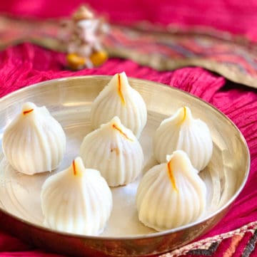Ukadiche Modak (sweet rice dumplings) in a plate and lord Ganesha idol in the back