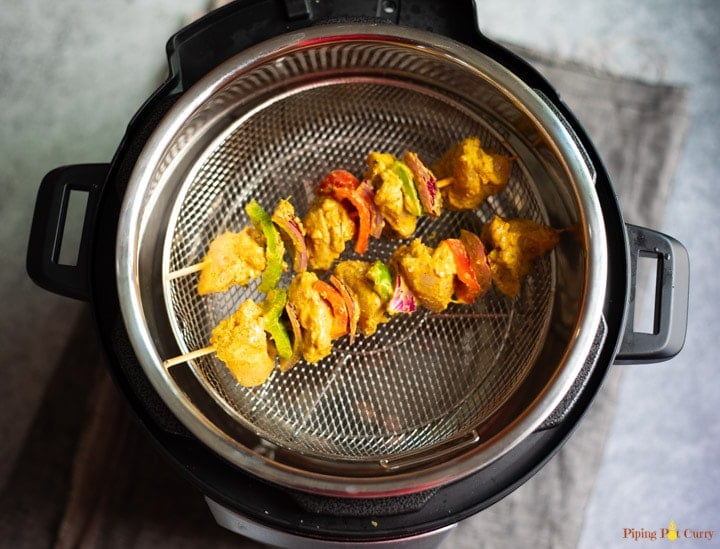 Chicken Tikka Air Fryer Crisplid - Piping Pot Curry Chicken and veggies skewer on the crisplid in the instant pot