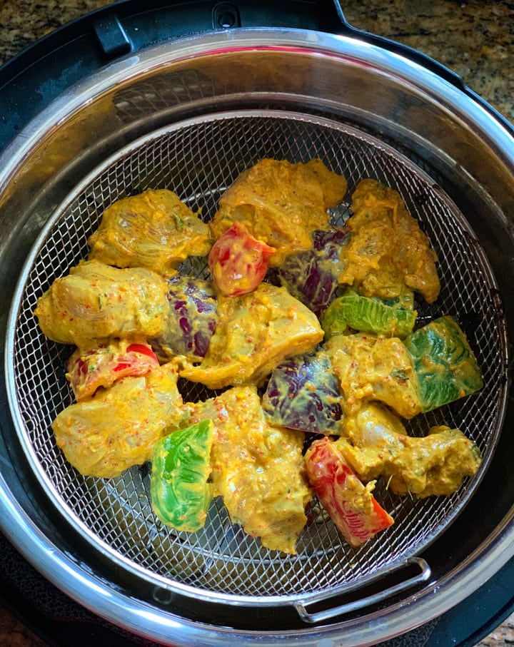 Chicken Tikka Bites in Instant Pot Crisplid - Piping Pot Curry Marinated chicken and veggies in a mesh basket inside a instant pot