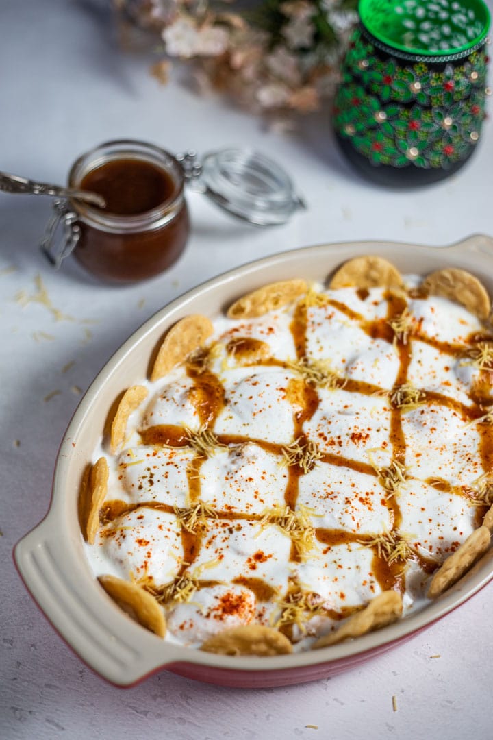 Dahi vada in a platter with papdi in the side and chutneys decorated on top