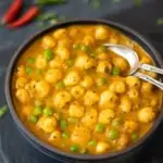 Vihreitä herneitä ja ketunpähkinöitä sisältävä curry (Matar Makhana) kulhossa 2 lusikallista