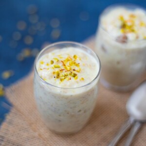 Indian Rolled Oats Kheer topped with pistachios and saffron in 2 small glasses