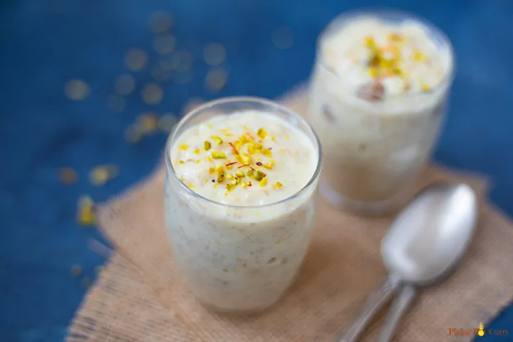Indian Rolled Oats Kheer topped with pistachios and saffron in 2 small glasses