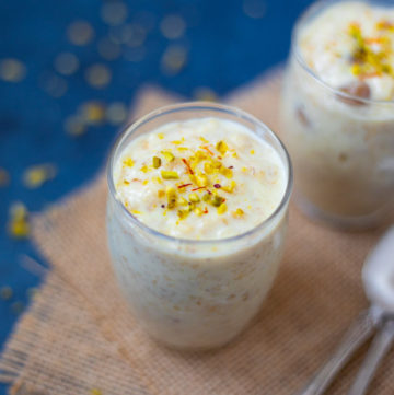 Rolled Oats Kheer topped with pistachios and saffron in 2 small glasses