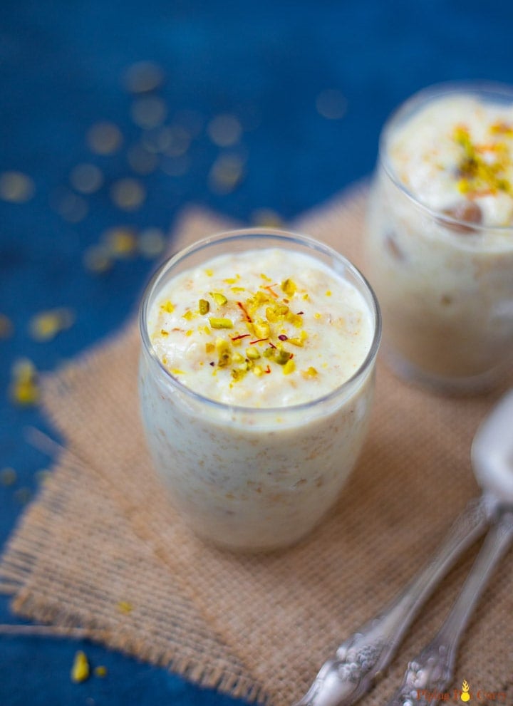 Rolled Oats Kheer topped with pistachios and saffron in 2 small glasses