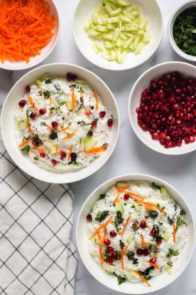 Yogurt rice garnished with pomegranate seeds served in two bowls
