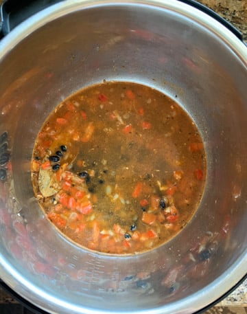 Black beans with tomatoes and spices being cooked in instant pot