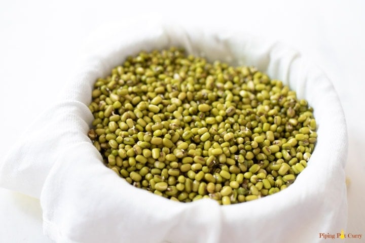 Soaked and drained green lentils in a white muslin cloth for sprouting