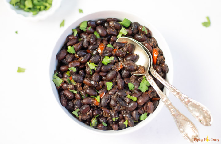 Mexican black beans in a bowl garnished with cilantro.