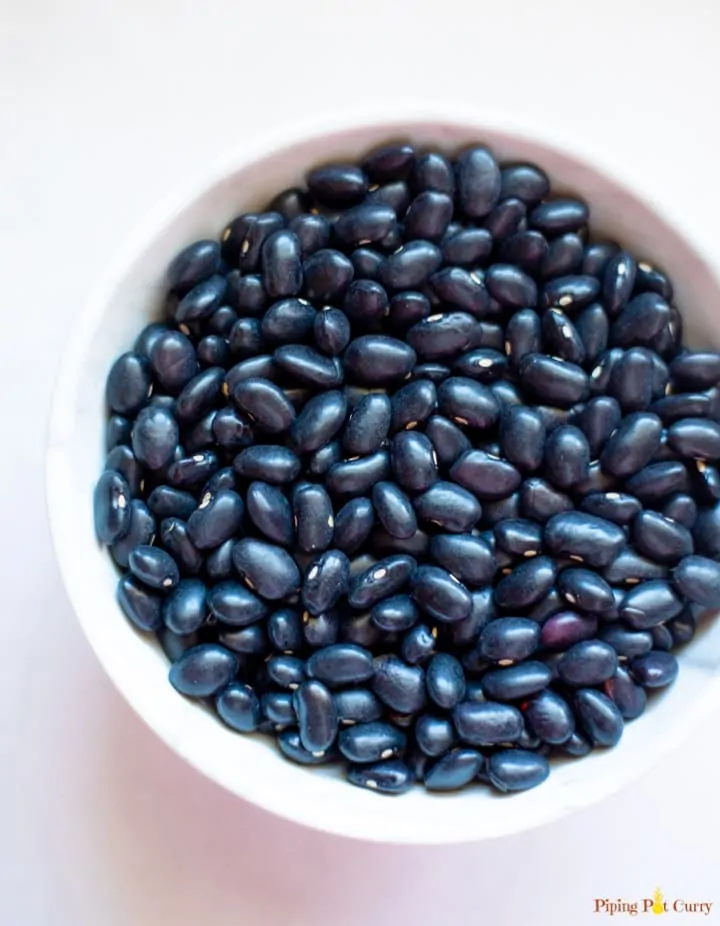 black beans in a round white bowl on a white background