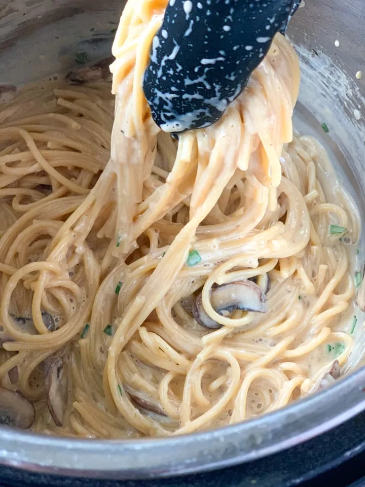 Creamy Spaghetti in tongs in a pressure cooker