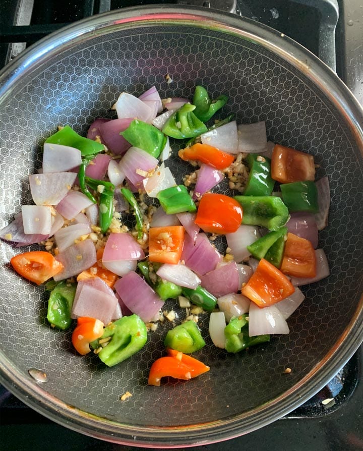 9. Saute onions, peppers for Chinese Chilli Chicken - Piping Pot Curry Onions and bell pepper sautéing in a pan