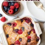Air Fryer Berry Bread Pudding in a baking pan with fresh berries on the side