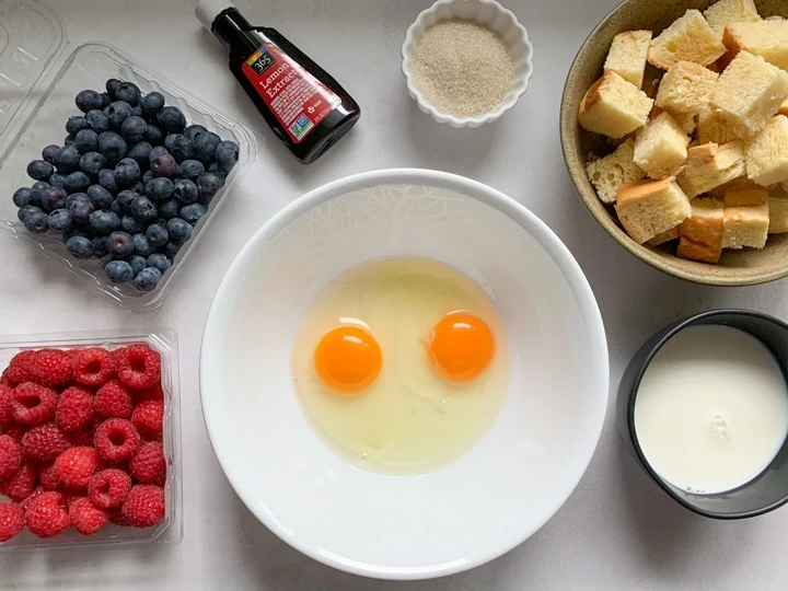 ingredients such as eggs, berries, brioche and sugar to make pudding