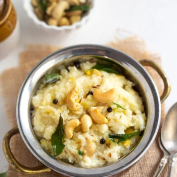 Ven Pongal in a bowl garnished with cashews and curry leaves