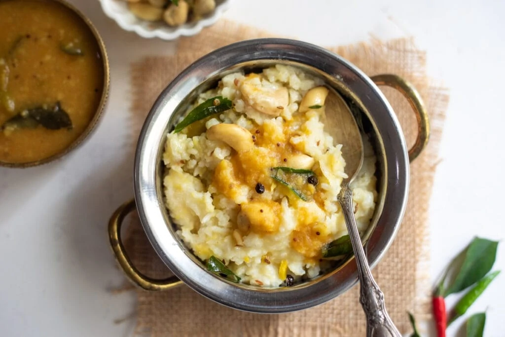 pongal in a bowl topped with sambar 