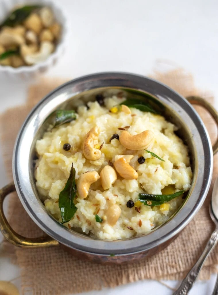Khatta Pongal in a bowl garnished with cashews and curry leaves