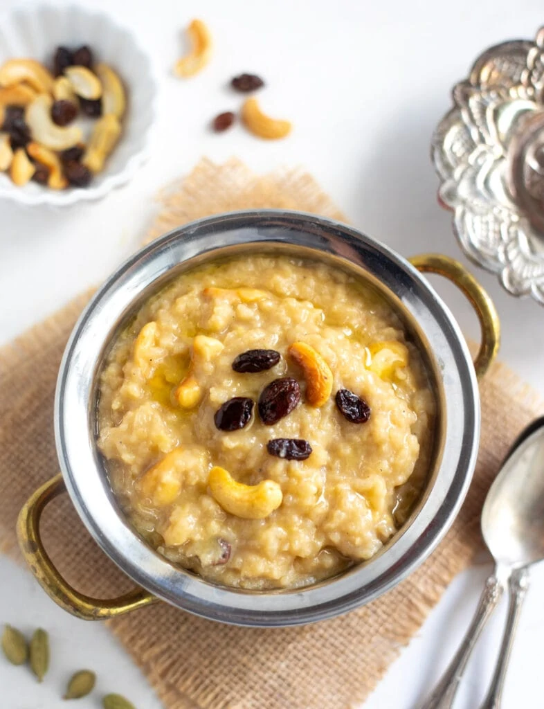 Chakkara Pongal served in a pretty brass bowl topped with roasted cashews and raisins
