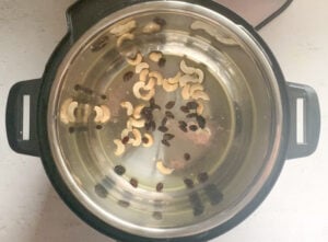 Roast cashews and raisins in a pot