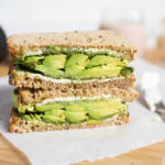 Sandwich with avocado, chutney and cream cheese on a cutting board