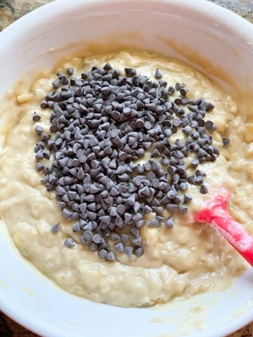 Banana Chocolate Chip Bread Steps - Piping Pot Curry-7 Mini chocolate chips in top of batter in a white bowl