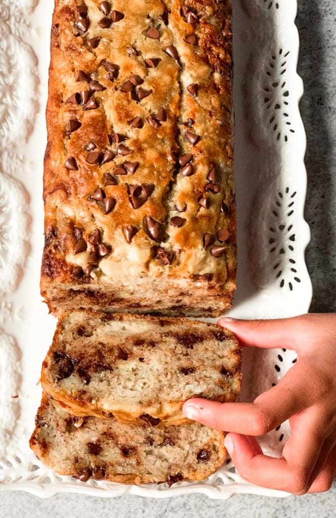 Kid hands picking a slice of banana chocolate chip bread