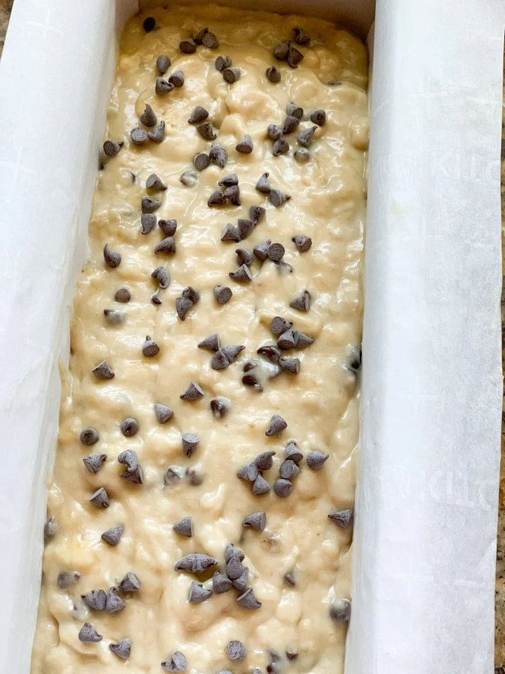 Batter topped with chocolate chips in a loaf pan