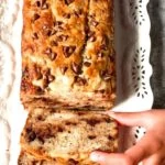 Banana Bread with chocolate chip slice being taken by hand