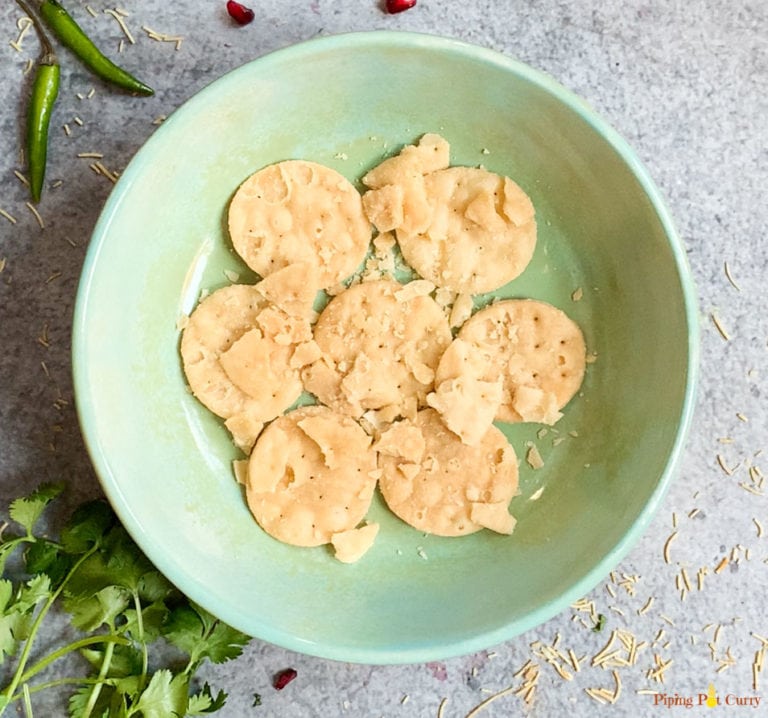 papdi (whole wheat crackers) in a green bowl