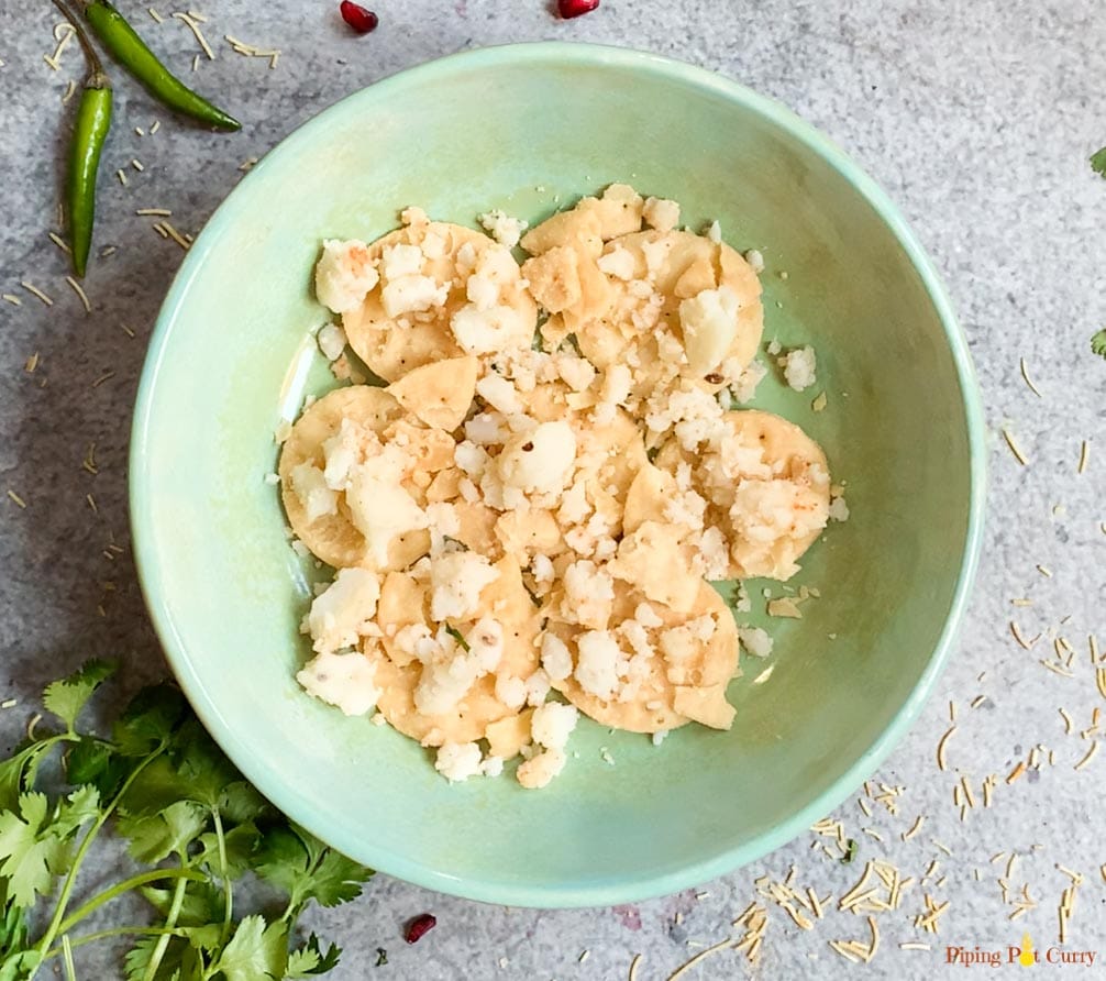 Papdi topped with potatoes in a bowl