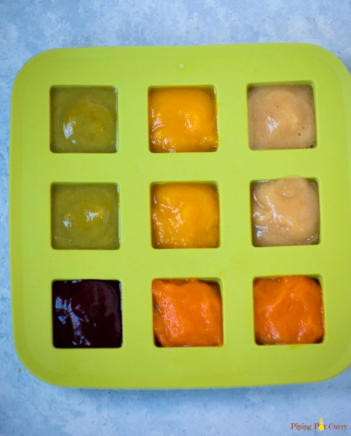 a silicone ice cube tray filled with various purees
