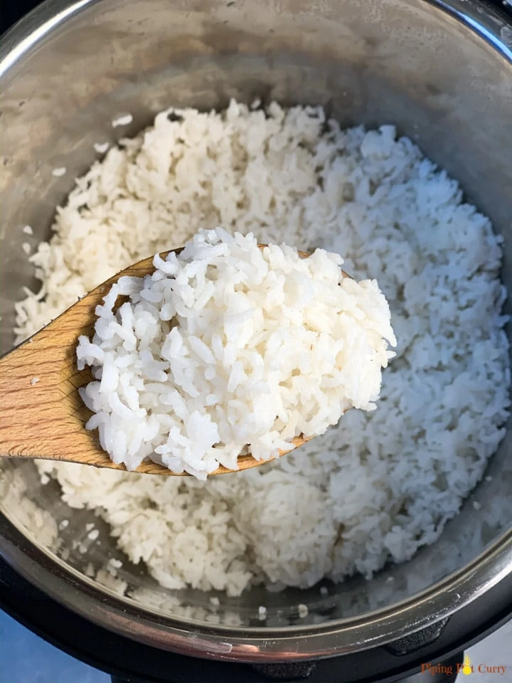 Cooked rice in a spatula over instant pot