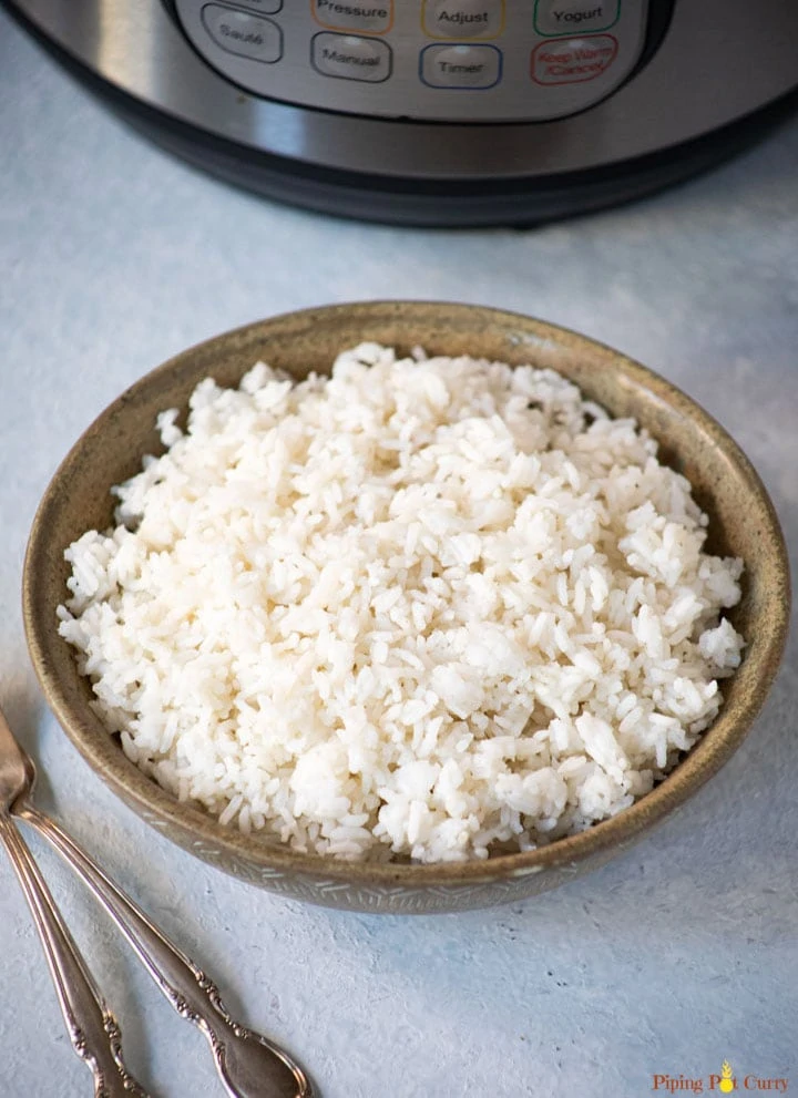 White sona masoori rice in a bowl in front of the instant pot
