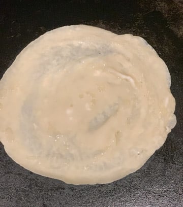 Paneer Frankie Recipe Steps - Piping Pot Curry-2 Batter spread to make a flatbread on a Tawa