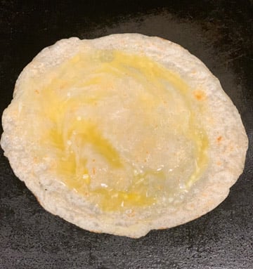 Paneer Frankie Recipe Steps - Piping Pot Curry-5 Whisked Egg spread on top of a roti