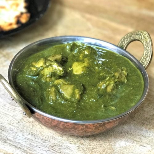 Chicken Saag in a copper kadhai on a wooden table