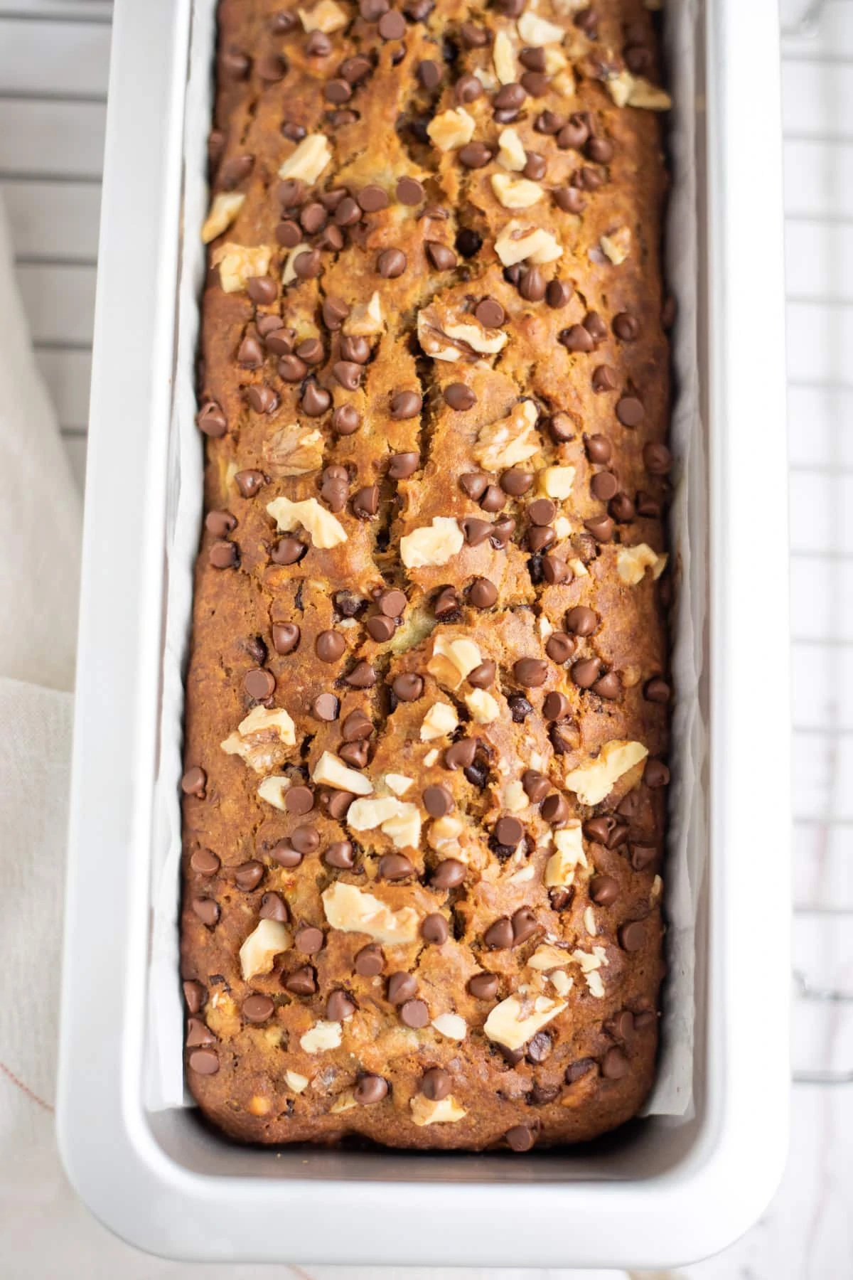 Baked Bread in a baking pan topped with chocolate chips and walnuts 