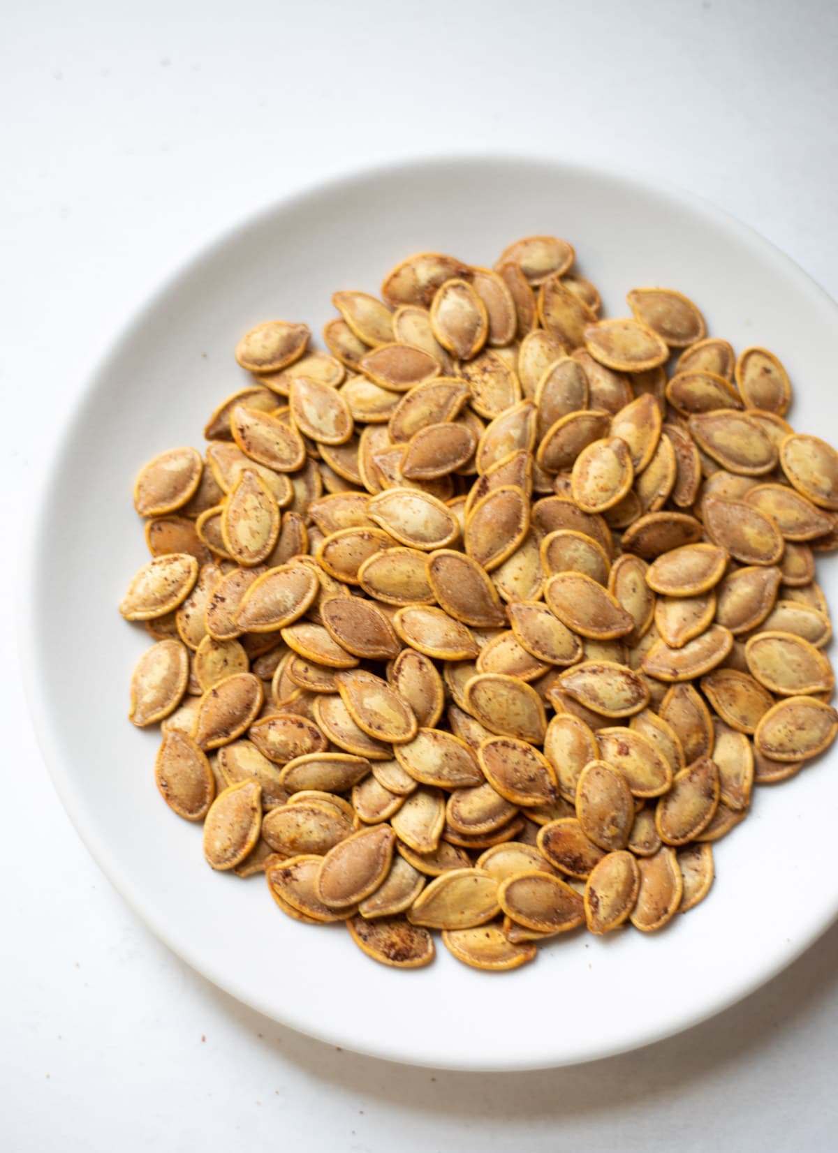 Roasted pumpkin seeds in a white plate