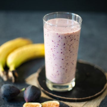 Fig Banana Smoothie in a glass with the ingredients around the glass