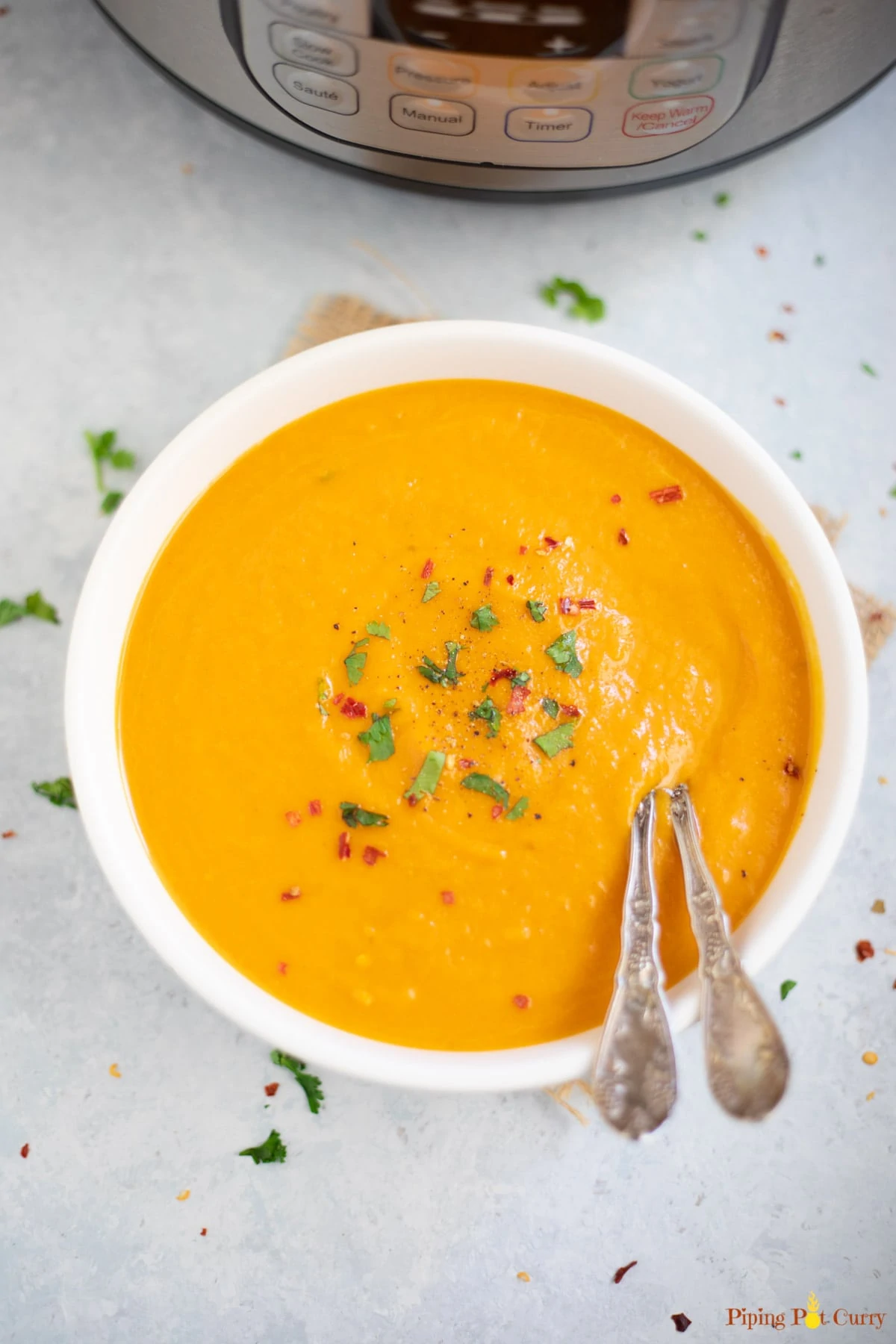 A bowl of carrot soup in front of the instant pot