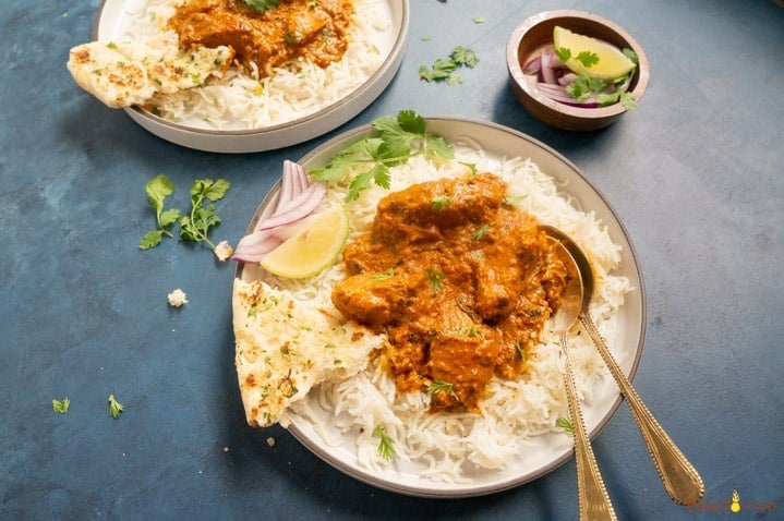chicken tikka masala in a plate served with rice and naan