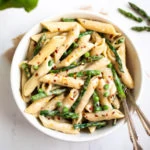 Penne Pasta with green Asparagus and peas in a white bowl