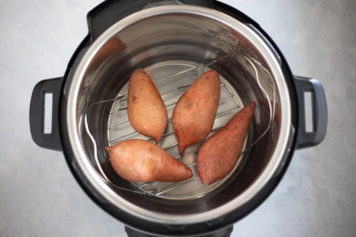 Sweet potatoes on a trivet in an instant pot to be cooked