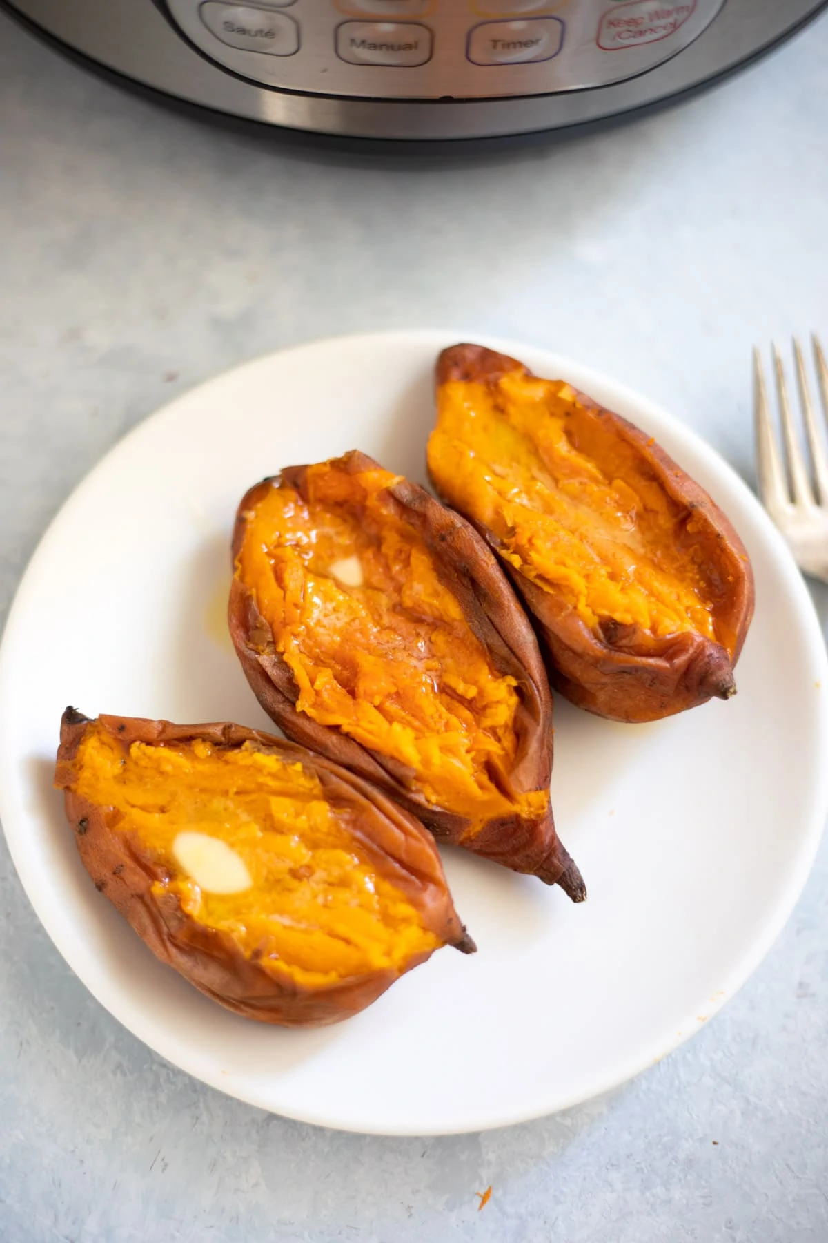 Three Creamy buttery Sweet potatoes in a plate in front of the instant pot