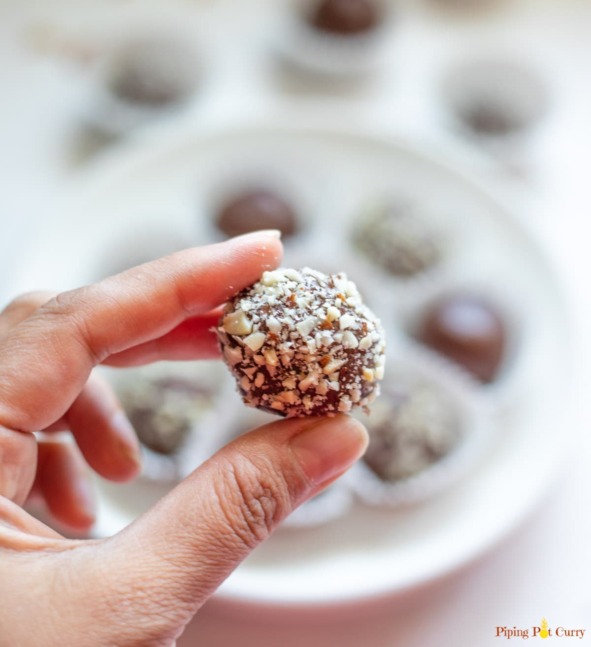 Closeup of a Chocolate Ladoo ball covered with chopped almonds 