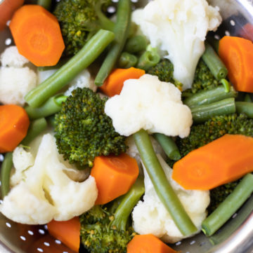 a medley of steamed vegetables in a steamer basket