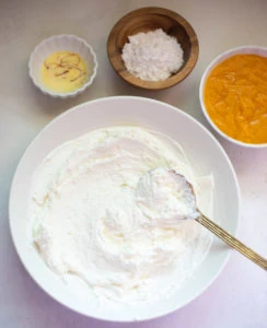 Hung curd in a bowl with other ingredients such as mango pulp, sugar and saffron in milk