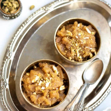 Moong Dal Halwa sweet served in 2 bowls topped with chopped nuts